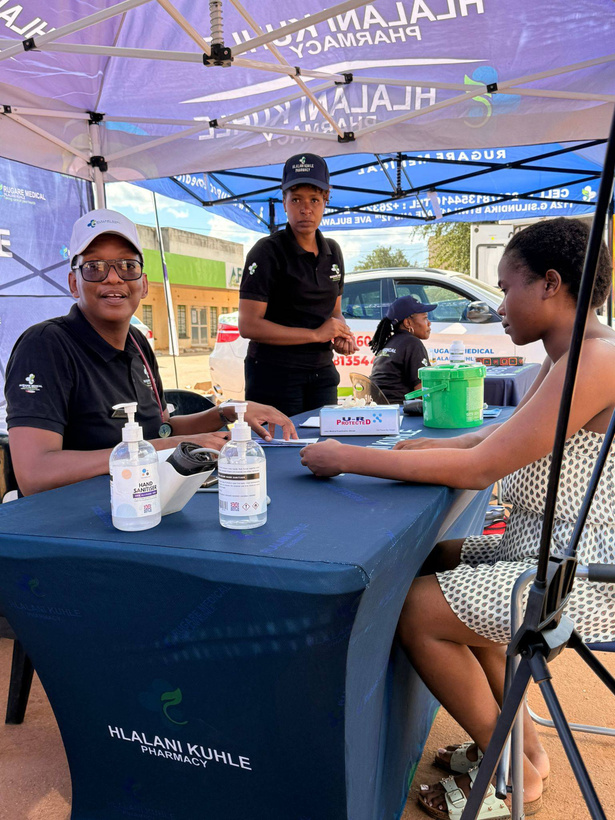 Rugare Medical staff speaking with a visitor at an outdoor wellness stand