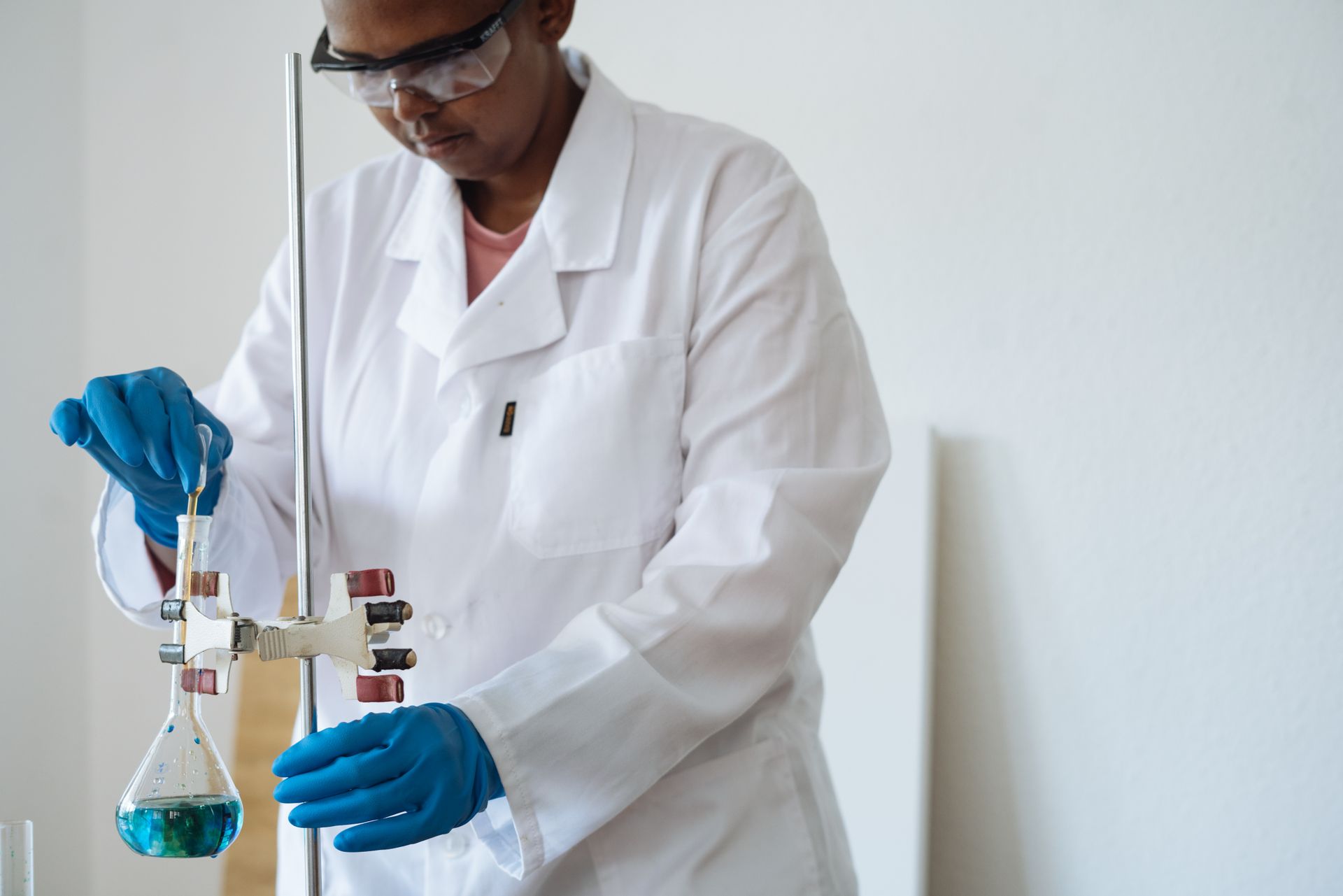 A Black laboratory professional carefully preparing a test sample
