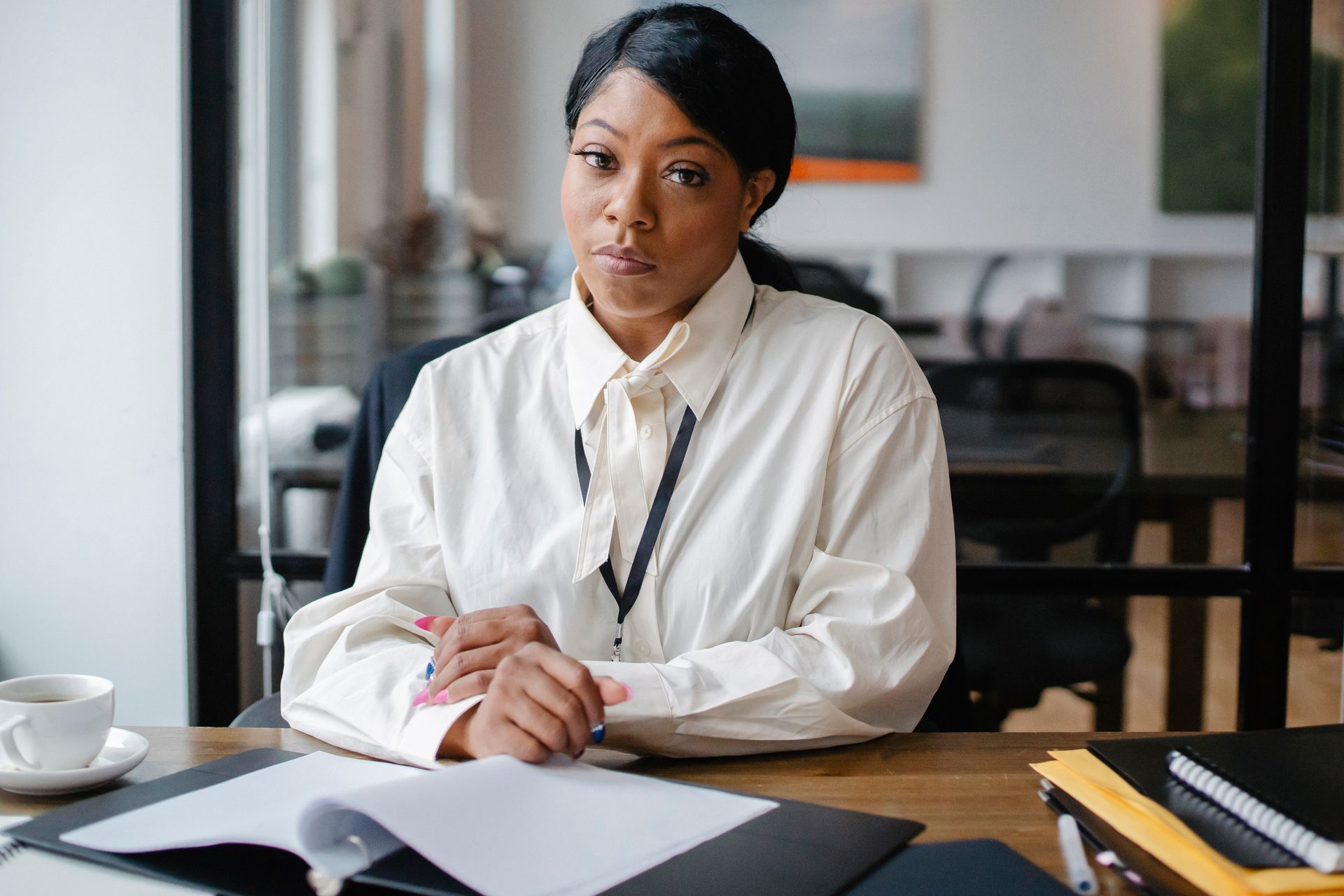 A Black business professional reviewing documents at her desk
