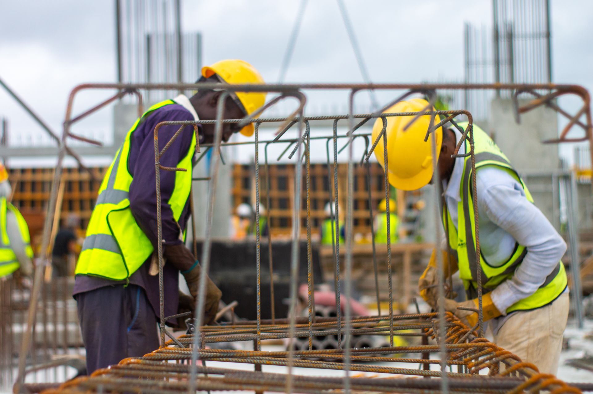 Black construction workers assembling steel reinforcement on a building site