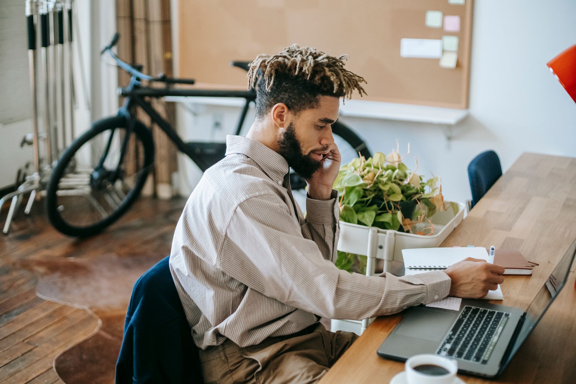 A professional using a laptop and mobile phone at a desk