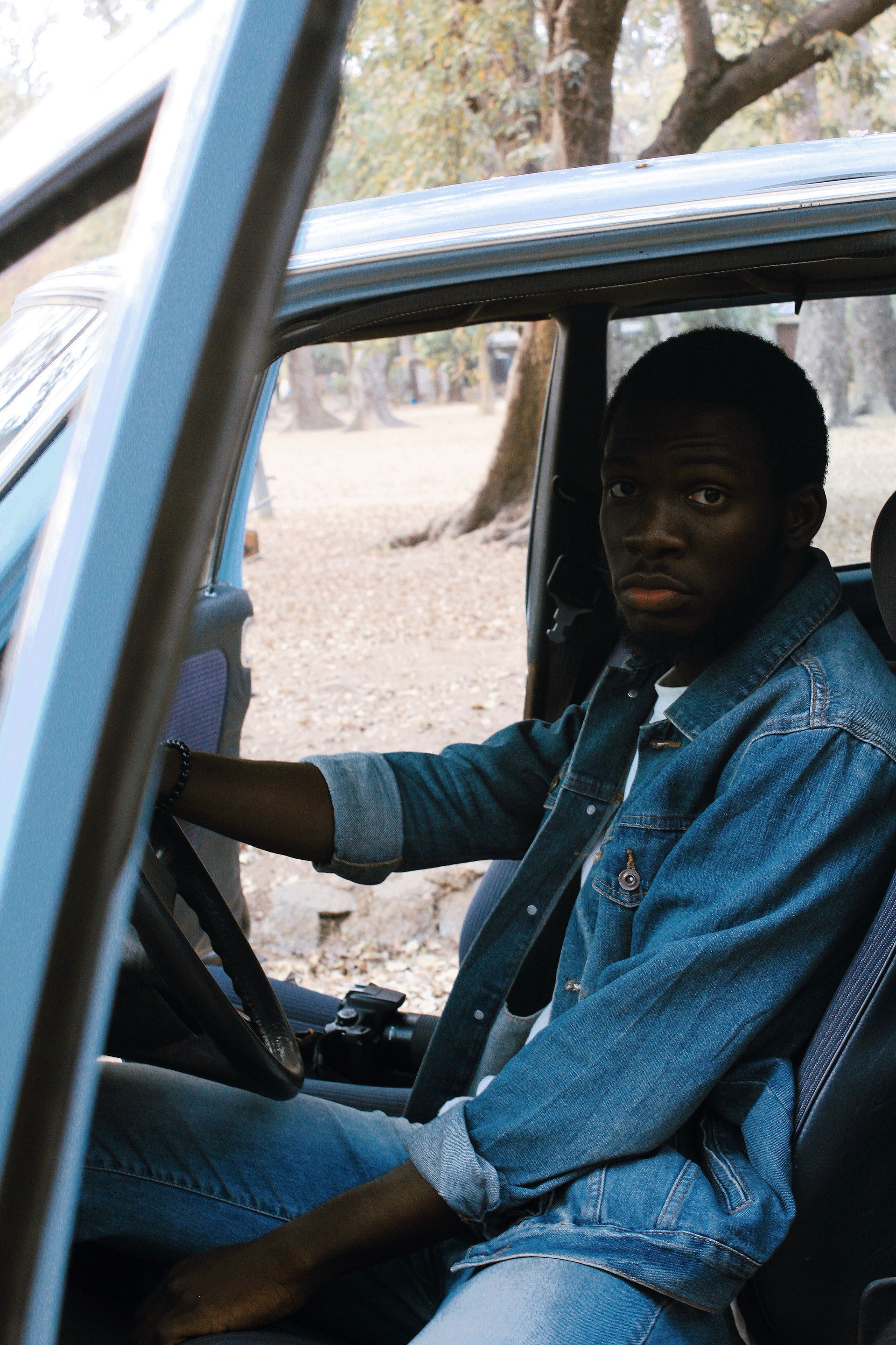 A Black driver seated behind the wheel of a car