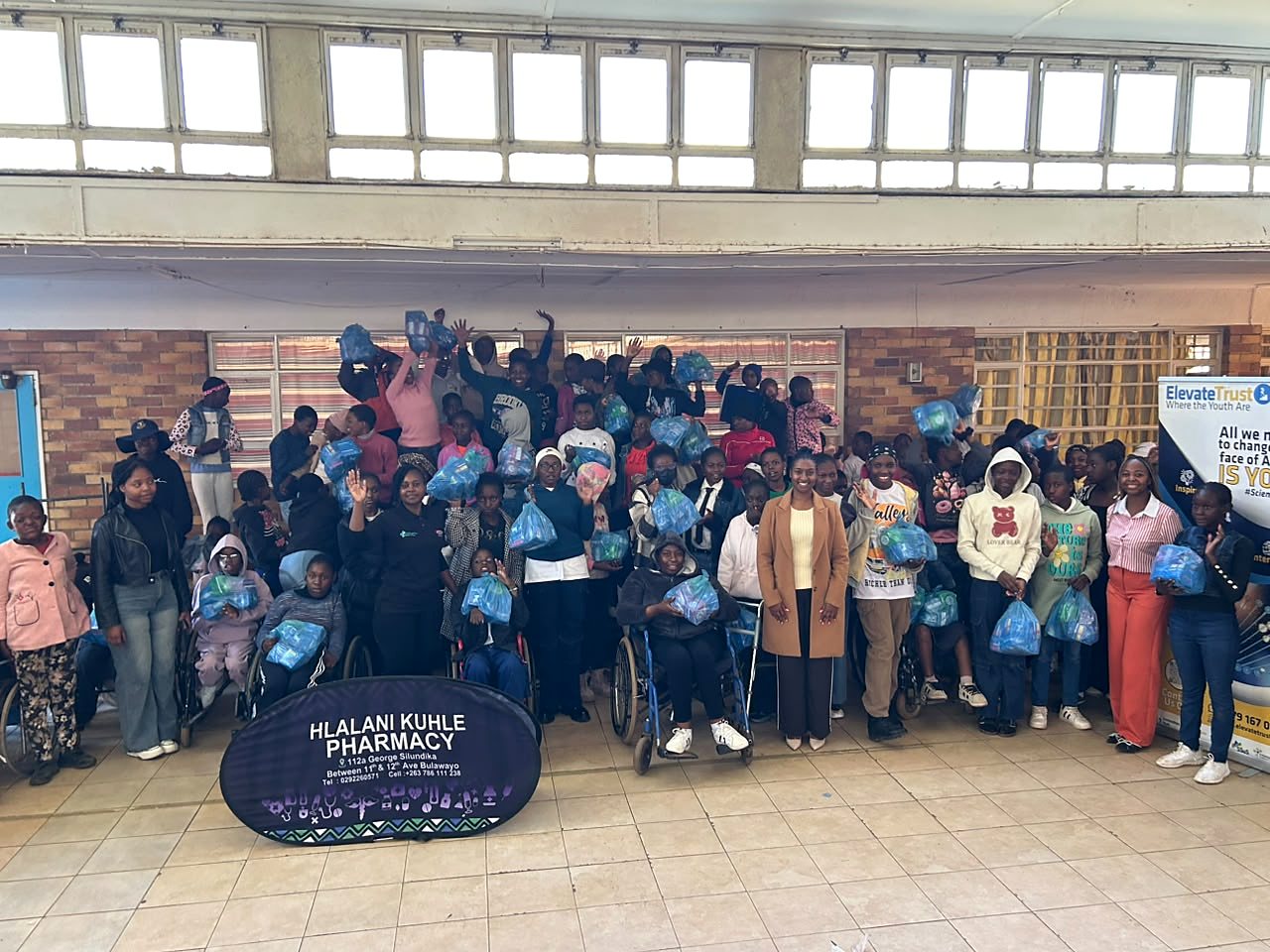 A large group of young people, wheelchair users and outreach representatives gathered with support packages