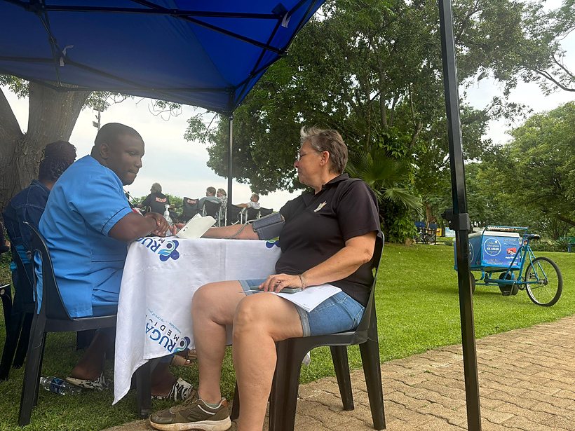 A healthcare worker checking a community member during an outdoor wellness activity