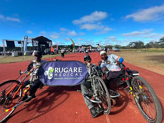 Adaptive sports participants holding a Rugare Medical banner at a community event