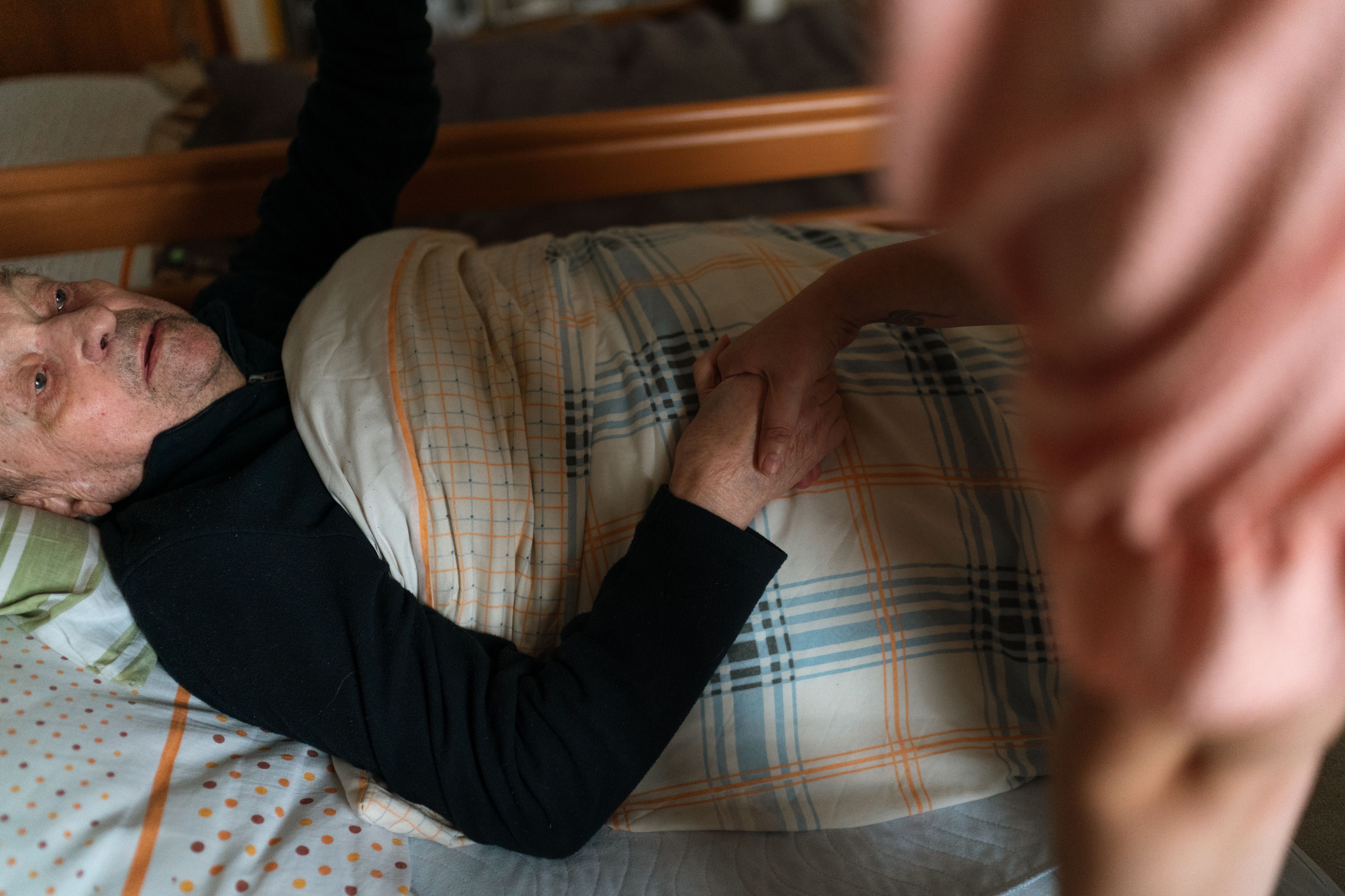 Photo of a caregiver supporting an older patient at home, representing home based care